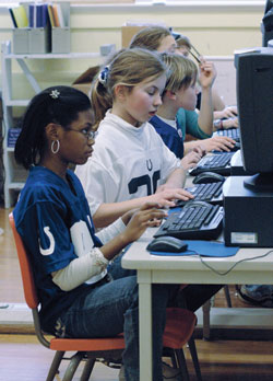 St. Joan of Arc School fifth-grade students Jaela Payne, from left, Mary Cate Pachciarz and Sam Osborn place their Accelerated Reader (AR) data onto a Microsoft Excel spreadsheet during a technology class on Jan. 11 at the Indianapolis North Deanery grade school. This project helps them track their overall progress, view their reading comprehension success and learn how to analyze the data. (Photo by Mary Ann Wyand) 