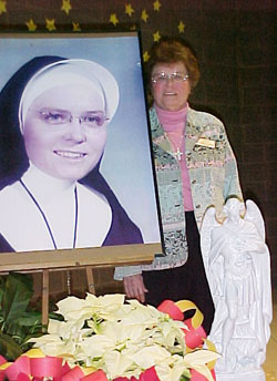 Providence Sister James Michael Kesterson has spent 60 years in Catholic education, serving the last 32 years as the principal of St. Jude School in Indianapolis. This photo was taken on her 80th birthday as she stood by her portrait taken in 1948. (Submitted photo)