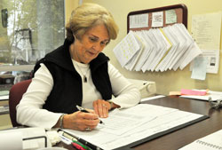 Mary Gilmartin, bookkeeper for St. Jude Parish and School in Indianapolis, works at her desk on Oct. 19. Her use of the Healthcare Blue Book website helped her find a facility that could do a myoview stress test on her heart that was a quarter of the price that would have been charged at her regular hospital. (Photos by Sean Gallagher)