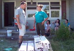 As coordinator of disaster preparedness and response for Catholic Charities in the archdiocese, Jane Crady talks with volunteer Pierre Gerber about the next step in restoring a home in Henryville that was damaged by a deadly tornado on March 2. Crady says she has experienced the touch of God daily in the volunteers who have come to help restore people’s homes and lives. (Submitted photo)