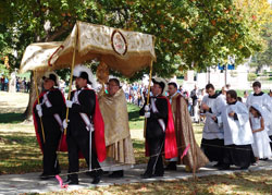 Father Robert Robeson, rector of Bishop Simon Bruté College Seminary in Indianapolis, carries a monstrance during the “Eucharistic Rosary Rally for the Protection of Our Religious Liberties” procession on Sept. 30 at Marian University in Indianapolis. Father Jerry Byrd, associate pastor of St. Barnabas Parish in Indianapolis, follows him with members of the Fourth Degree Knights of Columbus and archdiocesan seminarians. (Submitted photos by Daniel Roy)