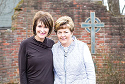 Sisters Jeanne Schmidt, left, and Kathy Kruer smile in a grotto on the grounds of St. Elizabeth Catholic Charities in New Albany. The women will receive the Spirit of Hope Award at the organization’s annual fundraiser gala on April 27. (Submitted photo)