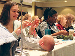 Ruby Dlugosz of St. Michael the Archangel Parish in Indianapolis holds a rosary over her 4-month old son, Daniel, during the Indiana Catholic Women’s Conference in Indianapolis on March 25. (Photo by Victoria Arthur)