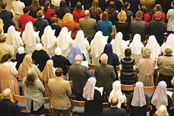 Sisters of various religious orders were present for the funeral Mass of Archbishop Emeritus Daniel M. Buechlein at SS. Peter and Paul Cathedral on Jan. 31. Standing for the recessional hymn in this photo is a row of Franciscan Sisters of the Immaculate Heart of Mary, wearing white veils. Among the religious sisters in the row behind them are three Missionaries of Charity, wearing white veils tucked into dark coats. Behind them wearing tan habits are two sisters and one postulant of the Daughters of Holy Mary of the Heart of Jesus, from Steubenville, Ohio. In the bottom row, right, are Little Sisters of the Poor in gray veils, and one postulant wearing a white veil. (Photo by Natalie Hoefer)