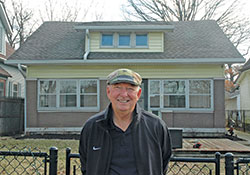 Robert “Lanny” Rossman smiles as he stands in front of the once-abandoned house in Indianapolis that he and his nephew Steve Adams spent 14 months transforming into a home for a single mother and her three children. (Photo by John Shaughnessy)