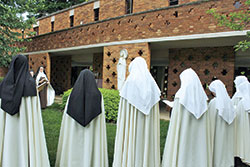 Members of the Carmelite Monastery of St. Joseph in Terre Haute pray before an outdoor shrine on the grounds of their monastery. The nuns in the cloistered community do not ordinarily go beyond the grounds of its monastery. (Photo courtesy of the Monastery of St. Joseph)