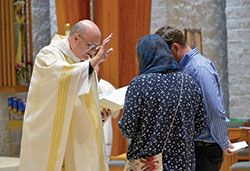 A couple receives a blessing from Msgr. William F. Stumpf, archdiocesan vicar general, after the Healing Mass for Mental Health Awareness on Sept. 15 in St. Mark the Evangelist Church in Indianapolis. (Photo by Natalie Hoefer)