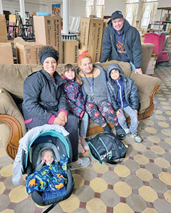 Dan Reichley, standing, poses with a family receiving twin bed kits from the Tri-County Good Samaritans St. Vincent de Paul Society in the Connersville Deanery. Reichley heads up the organization’s furniture ministry. (Submitted photo)