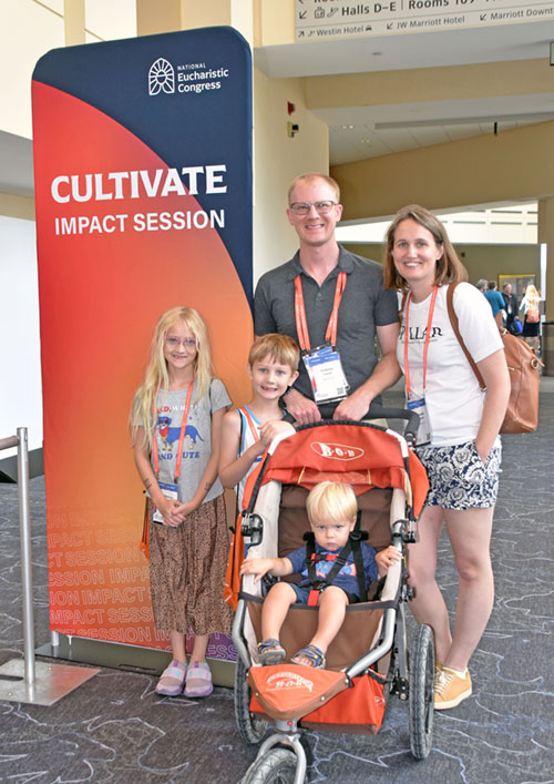 Andrew and Sara French of the Diocese of Richmond, Va., pose with their children in the Indiana Convention Center in Indianapolis on July 19 during the National Eucharistic Congress. Catherine, left, made her first Communion this year and walked with other first communicants during the eucharistic procession in downtown Indianapolis on July 20.