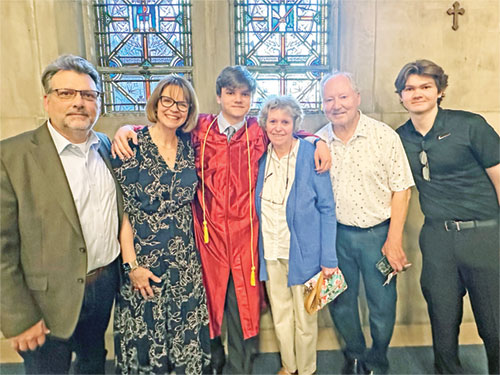 New archdiocesan director of communications Sally Krause, second from left, poses with her husband John, left; their sons Max, third from left, and Charlie, right; and her parents Jane and Jerry Allsop on May 23 in Our Lady of Lourdes Church in Indianapolis at the 2024 Baccalaureate Mass for Father Thomas Scecina Memorial High School in Indianapolis. All six are members of Our Lady of Lourdes Parish. (Submitted photo)